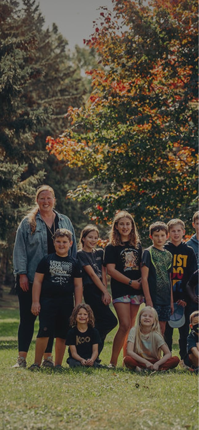 Group of children posing for photo in a park.