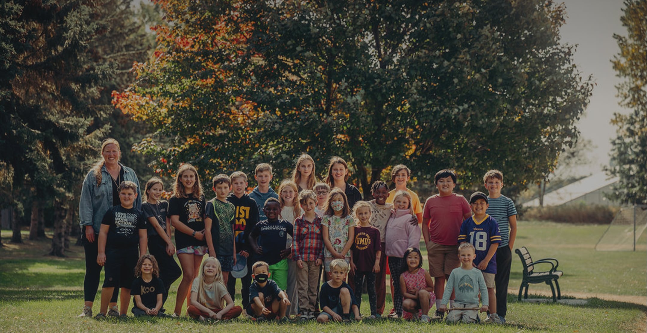 Group of children posing for photo in a park.