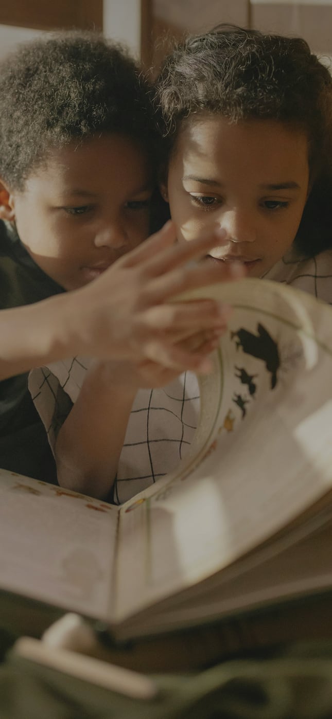 Two children reading a book.